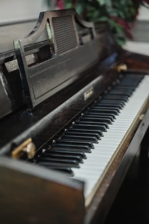 Upright piano beside a window.
