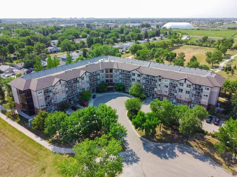 Aerial view of the multi-storey residence and surrounding streets and trees.