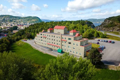 Aerial view of the residence, driveway and surrounding trees.