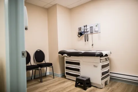 Examination room with a medical couch and equipment.