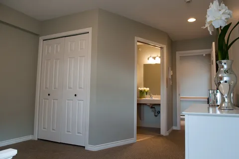 Room with a closet, dresser and an open doorway to a bathroom