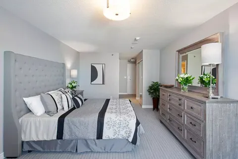 Bedroom with a bed, dresser, mirror and bedside lamps