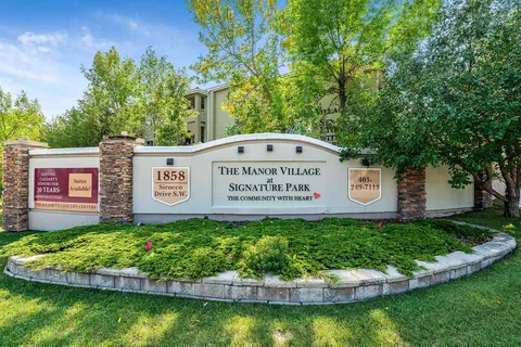 Residence sign beside shrubs and trees