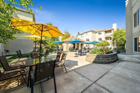 Courtyard patio with tables, umbrellas, flowers and a covered shelter