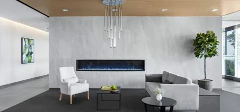 Sofa and armchair beside a long wall fireplace