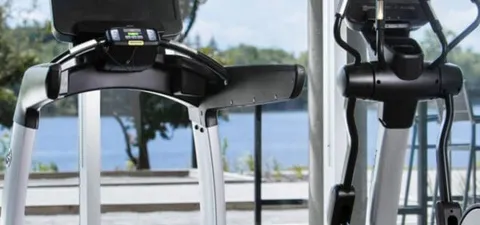Exercise equipment beside large windows overlooking water