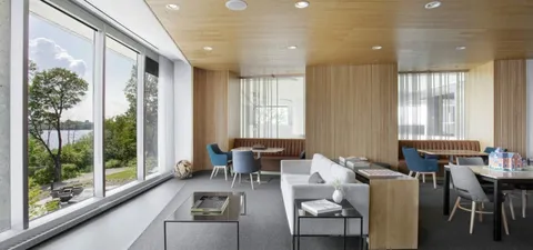 Seating area with a sofa and tables beside large windows