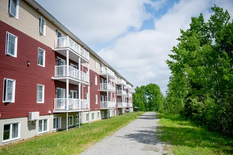Residence facade and balconies beside a paved path.