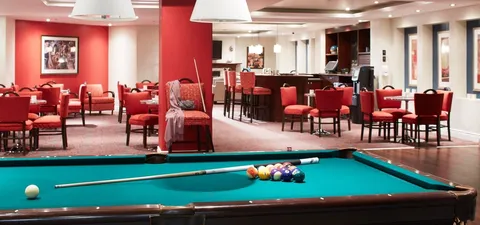 Games area with a pool table and red lounge seating
