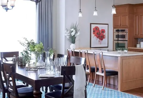 Suite kitchen and dining table beneath pendant lights