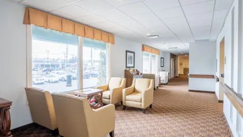 Sitting area with armchairs beside corridor windows.