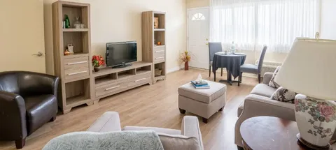 Suite living room with a sofa, armchairs, television and window.