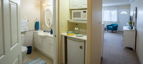 Suite bathroom doorway with a vanity and sitting area beyond.
