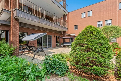 Garden seating area with a covered swing beside the building