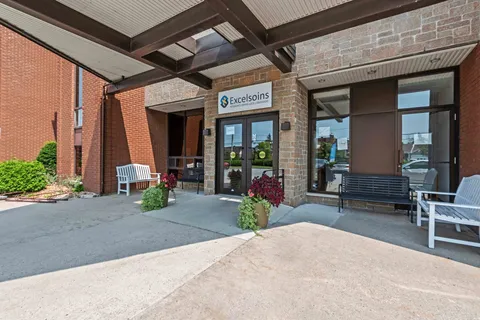 Covered brick entrance with glass doors and large planters