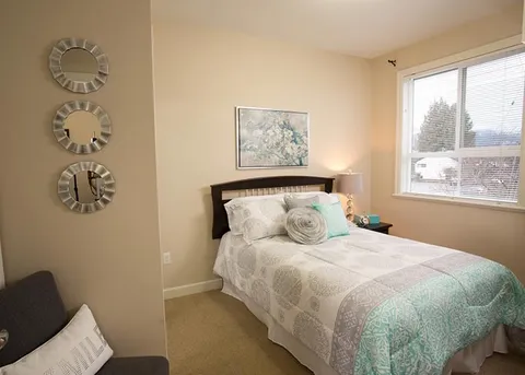 Suite bedroom with a bed beside a window.