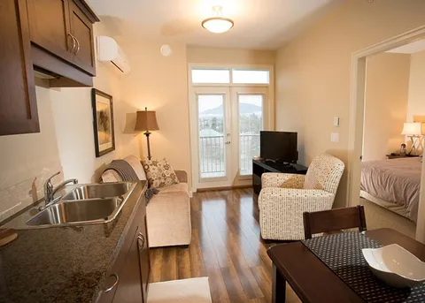 Studio suite with a bed, armchair and kitchenette.