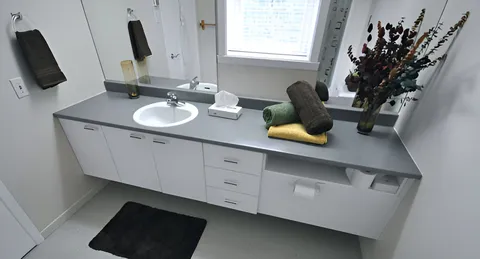Bathroom vanity with sink, mirror and window.