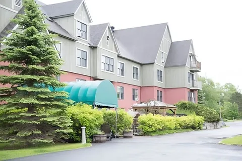 Residence exterior with green entrance awning and front landscaping.