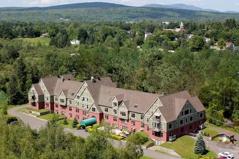 Aerial view of the residence beside trees and surrounding countryside.