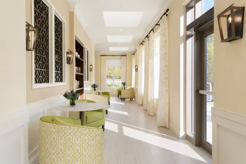 Sunroom corridor with armchairs and tall windows.