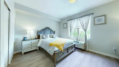 Bedroom with a double bed, dresser and curtained window