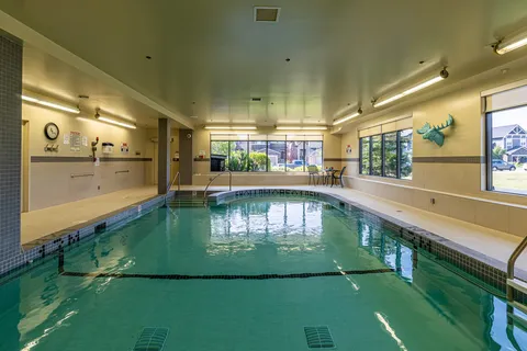 Indoor swimming pool with tiled walls and large windows