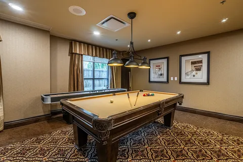 Billiards room with a pool table, shuffleboard table and horse pictures
