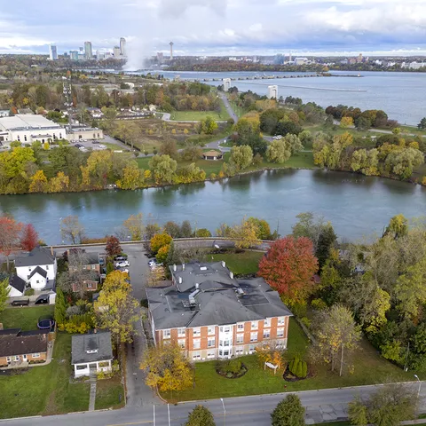 Aerial view of the residence beside a creek and surrounding trees.