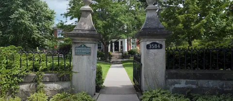 Stone gateposts and a path leading toward the residence entrance.