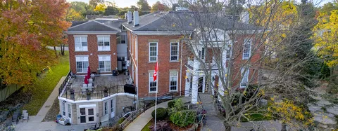Aerial view of the brick residence among trees in autumn.