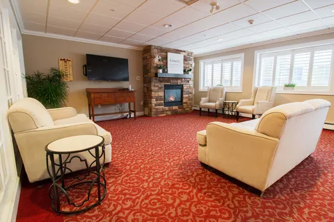 Armchairs and a sofa around a fireplace and blank television