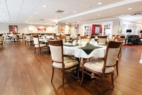 Dining tables and chairs with white tablecloths and floral artwork