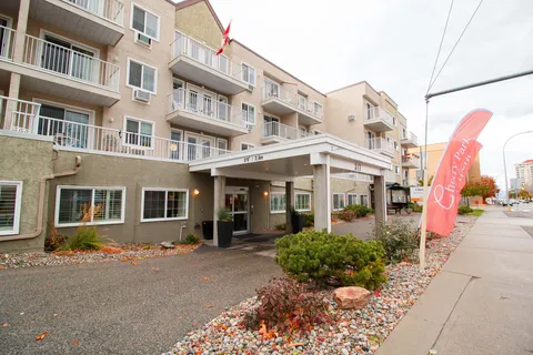 Multi-storey residence with balconies and a covered entrance beside the sidewalk