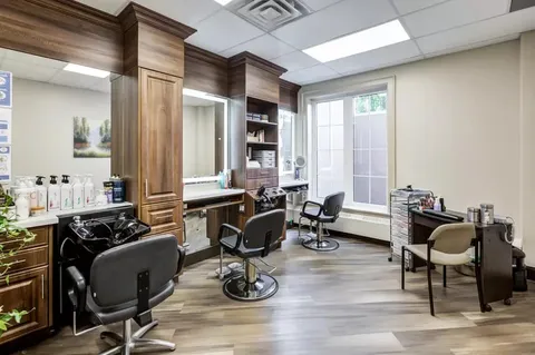 Salon with styling chairs, mirrors and a hair-washing sink