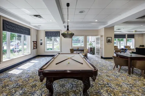 Games area with a pool table beneath a hanging lamp