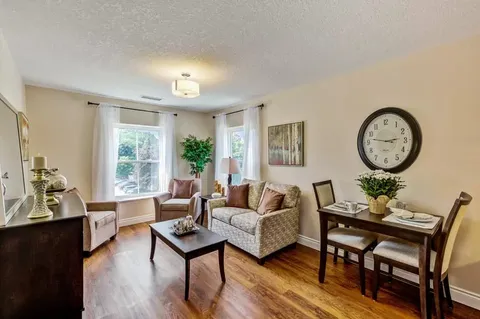 Sitting area with a sofa, armchairs, small dining table and large clock