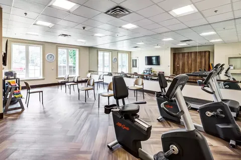 Exercise room with fitness machines, chairs and wall mirrors