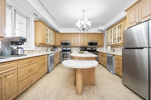 Kitchen with wooden cabinets, white counters and a central island