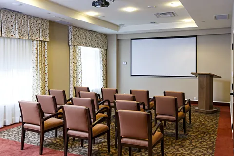 Theatre room with upholstered chairs and a blank projection screen