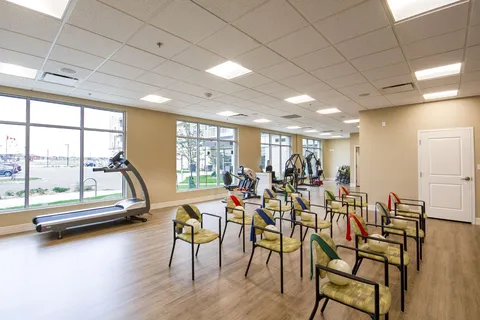 Fitness room with chairs, treadmill and exercise equipment.