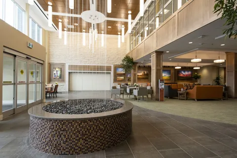 Atrium lobby with hanging lights, balconies and a circular fountain.