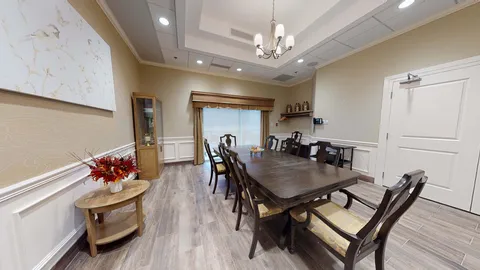 Private dining room with a long table, chandelier and sideboard.