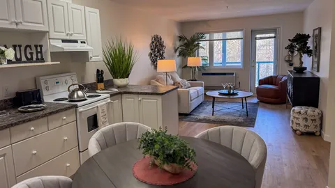 Suite kitchen, dining table and living area with a sofa.