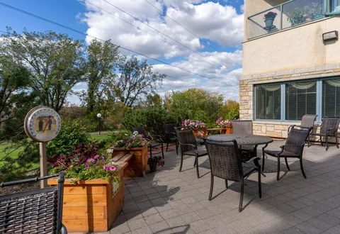 Patio tables and chairs beside raised planters.