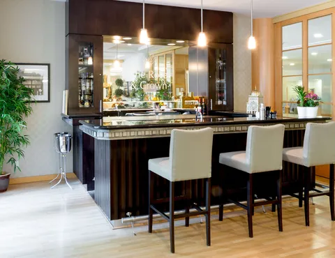 Bar lounge with counter seating, pendant lights and windows.