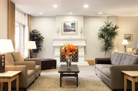 Common room with sofas, a fireplace and flower arrangement.