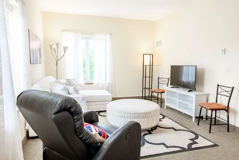 Sofa and reclining chair opposite a blank television