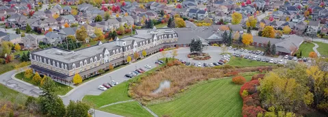 Aerial view of a residence building beside lawns and a parking area