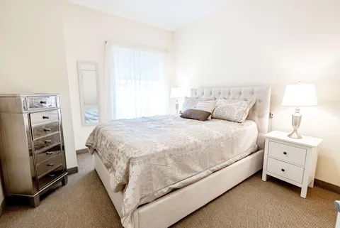 Bedroom with a double bed, bedside lamps and a mirrored chest